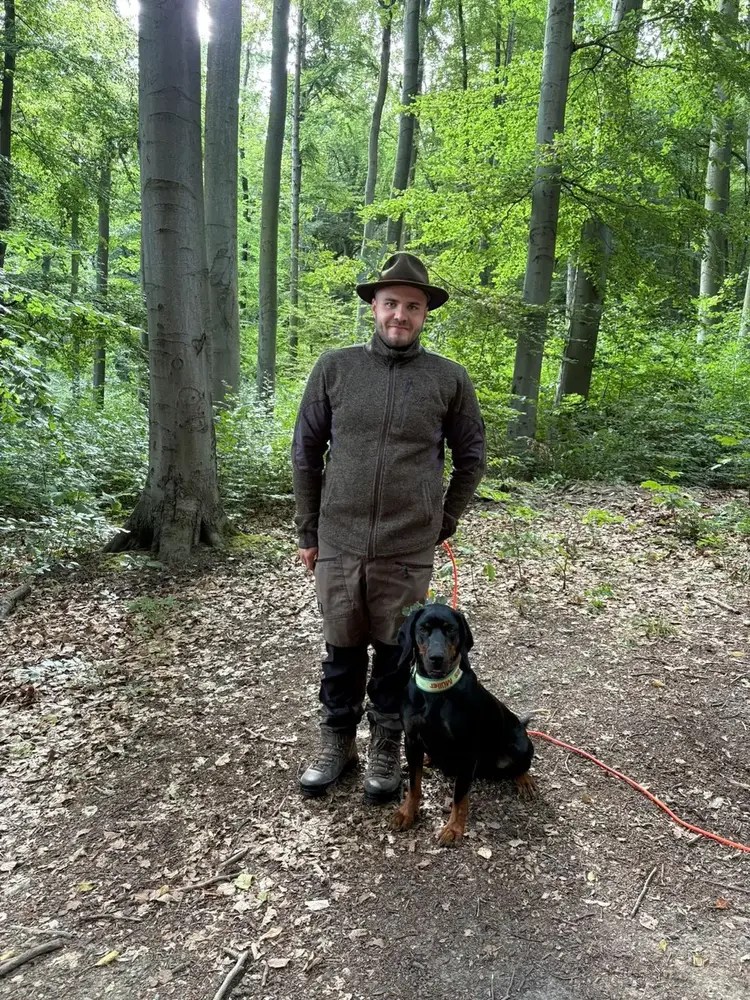 Caya mit ihrem Hundeführer im Wald